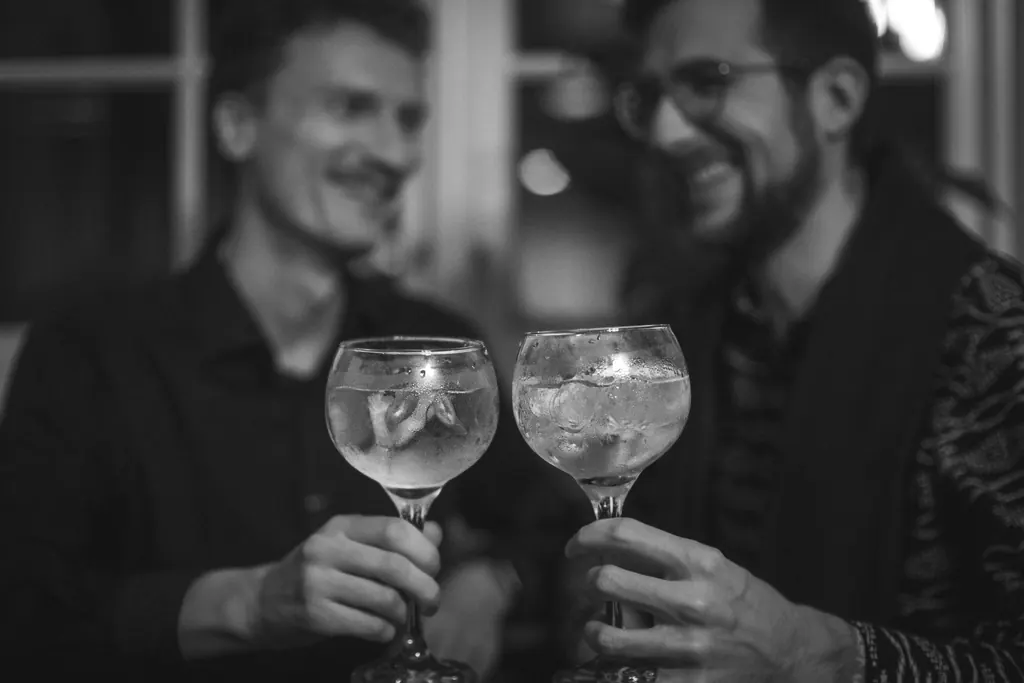 Black-and-white photo: Timmy and Jonny raising their glasses